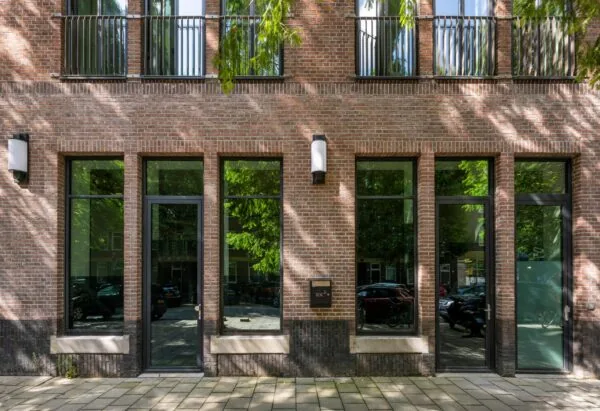 Voorgevel van een modern bakstenen appartementencomplex aan de Karel du Jardinstraat met grote ramen en twee entreedeuren.